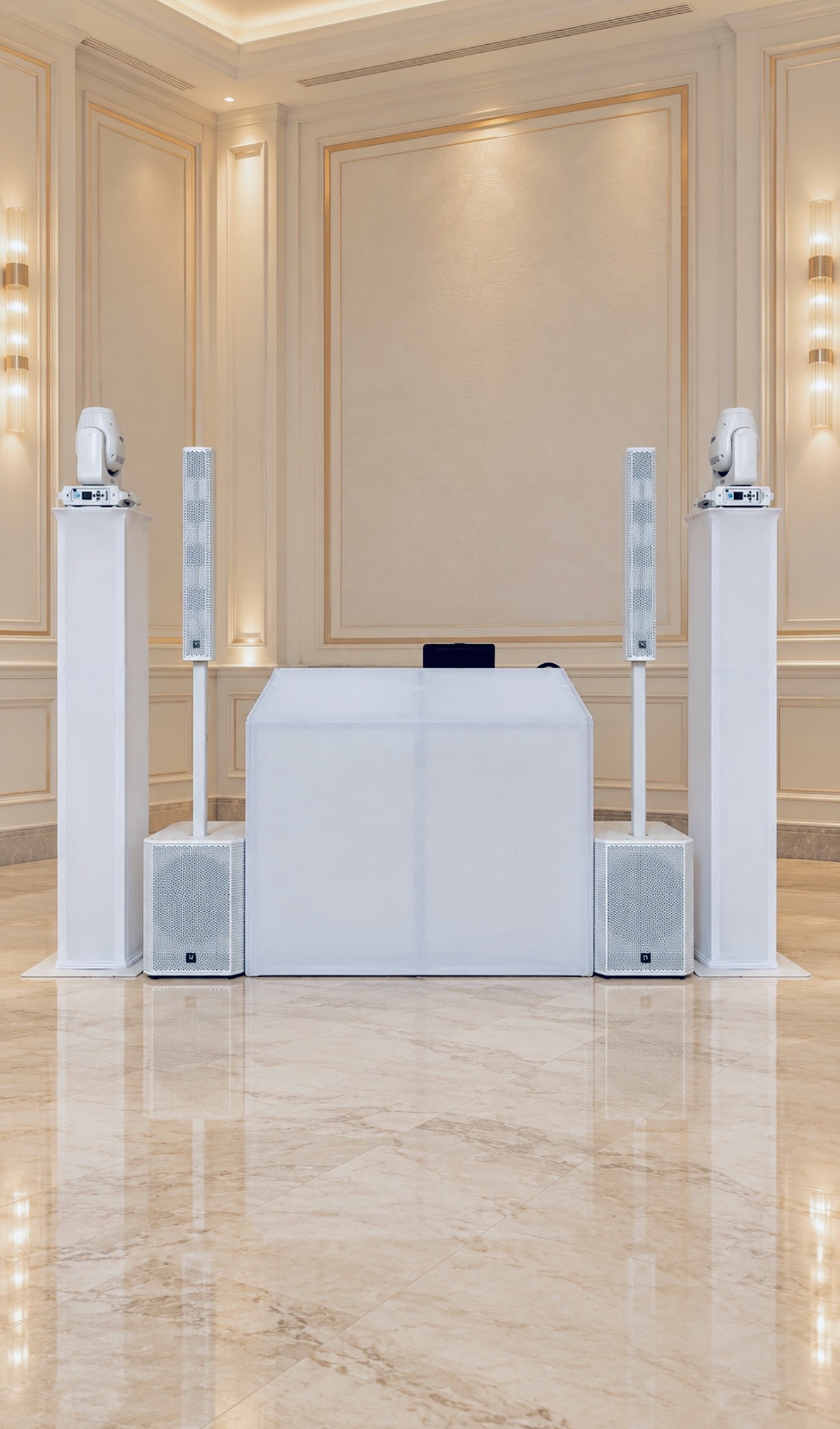 Butler Entertainment Solutions all-white DJ booth, speakers and moving-head lighting setup