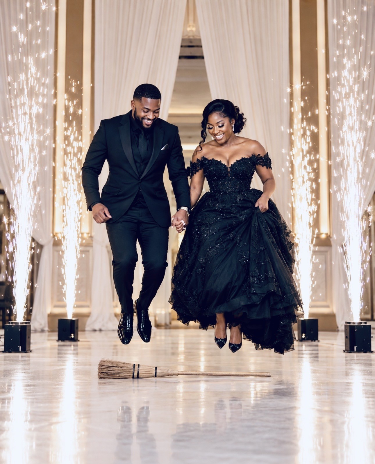 Couple jumping the broom surrounded by four cold spark fountains