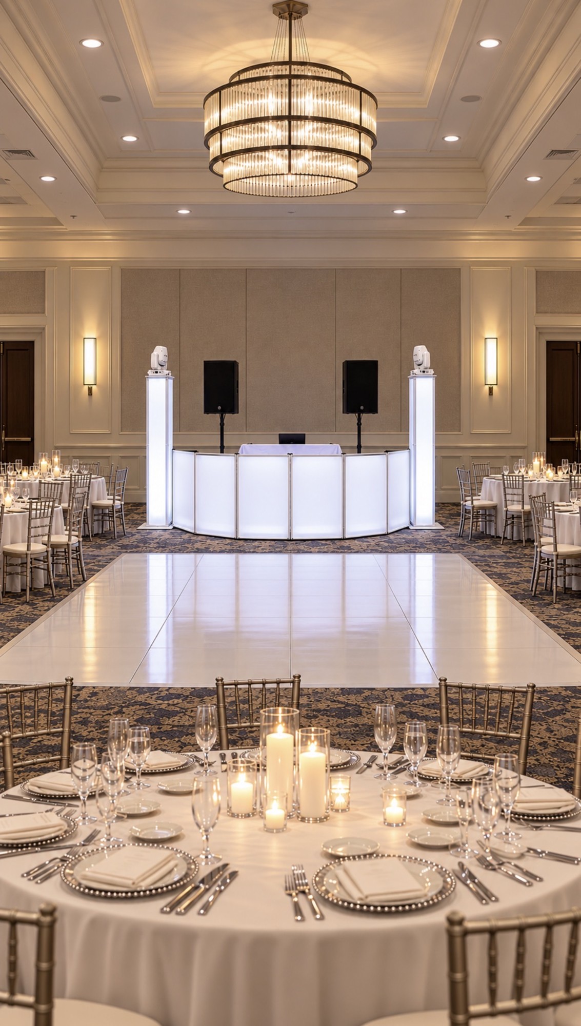 White illuminated DJ booth and lighting towers in an elegant ballroom